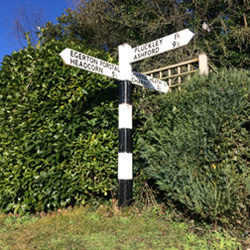 Wooden sign post at the junction of New Road and Stone Hill/The Street